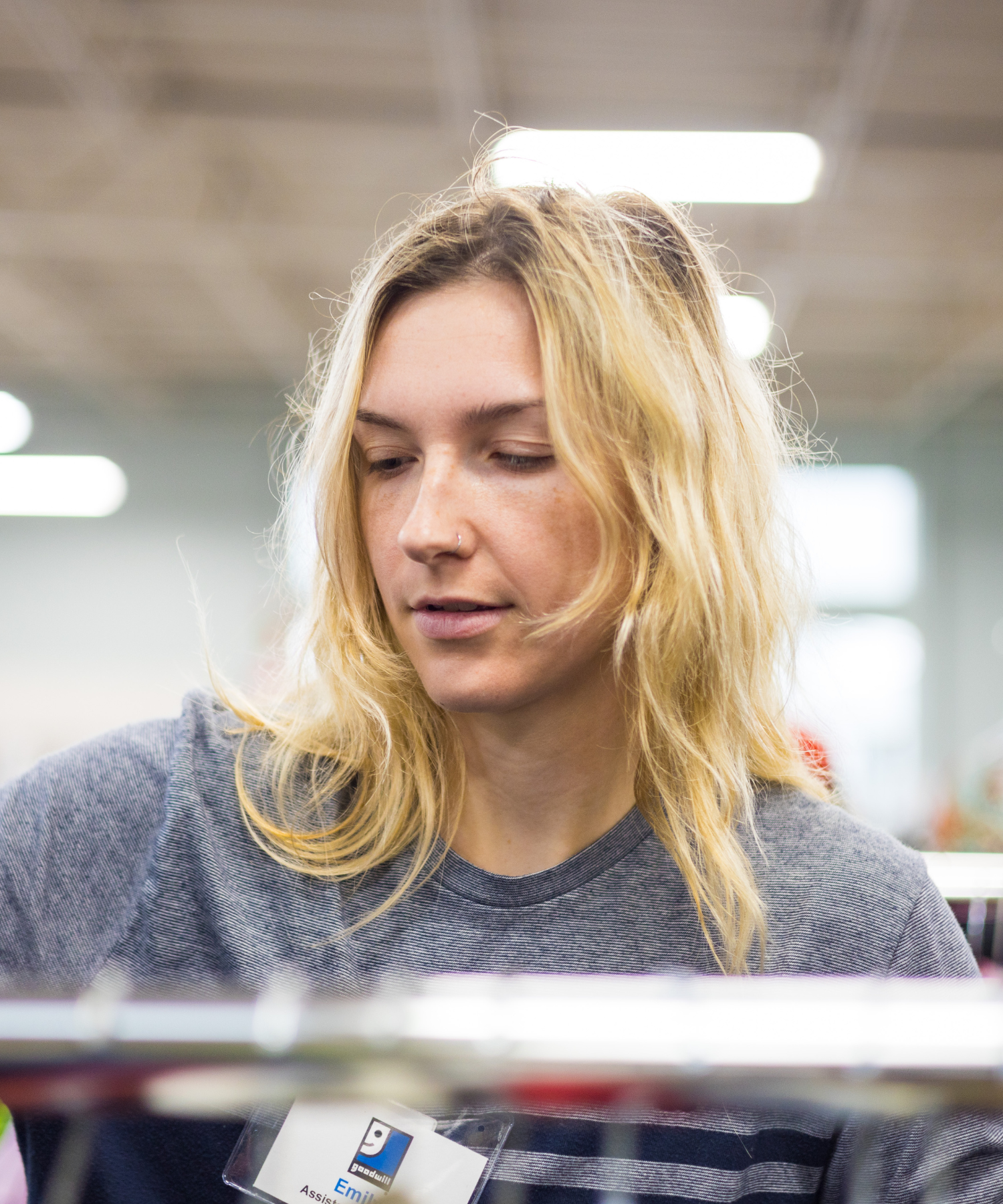 store employee at rack woman looking at rack